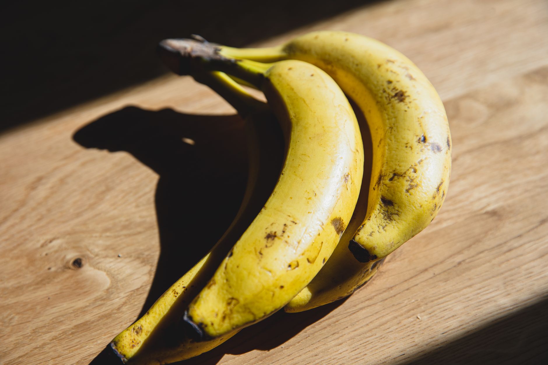 Banane et calories : combien apporte vraiment une banane moyenne au quotidien — bananes mûres sur une table en bois